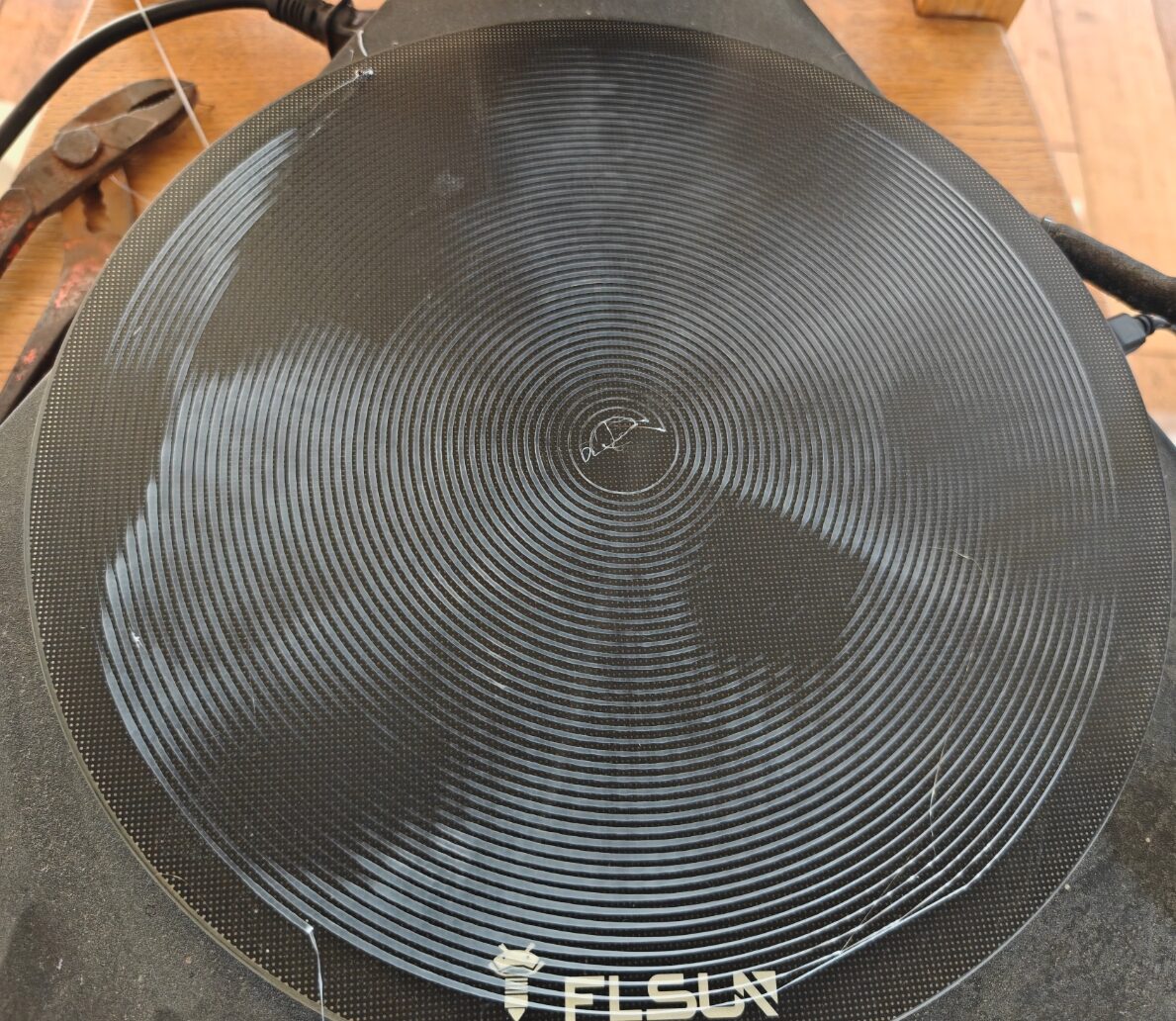 Spirale de nivellement sur le plateau rond de la FLSun QQ-S : trois secteurs brillants alternant avec trois secteurs sombres, en trèfle