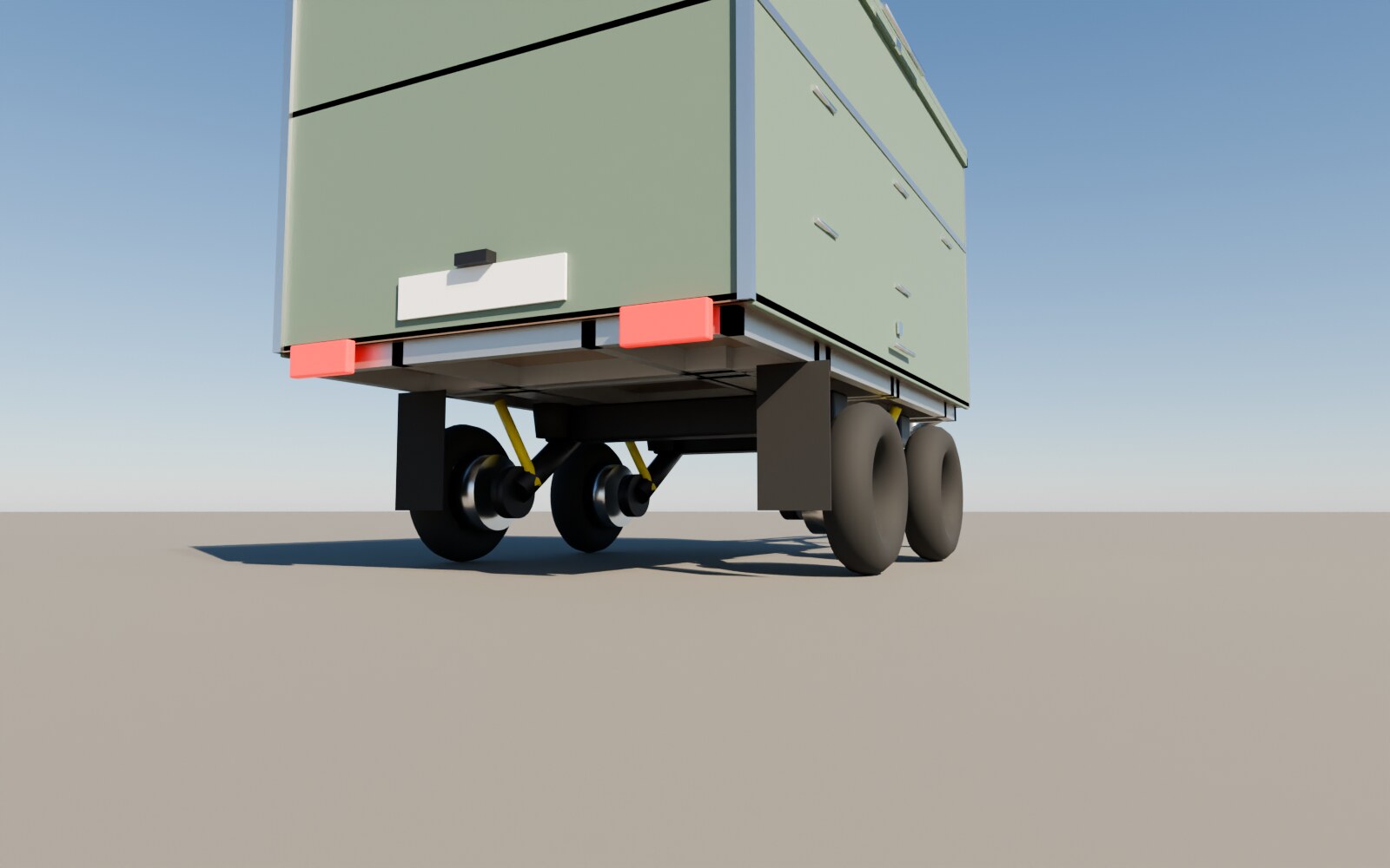 Vue de dessous de la remorque sur deux berceaux de Mini en tandem : quatre petites roues de 10 pouces, deux traverses noires, la caisse plus basse que sur les autres versions